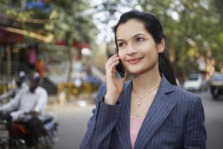 在城市街道上使用手机的女商人
