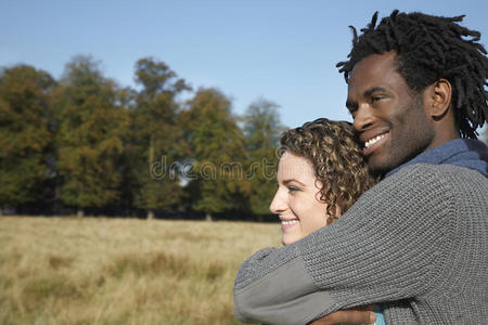 一对体贴的夫妇在田野里拥抱时，把目光移开