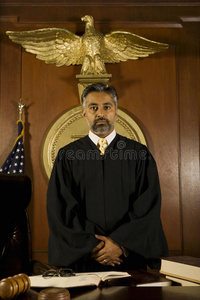 法官站在法庭的桌子旁图片