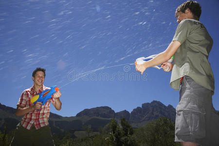 男孩子们在山上用水枪打架图片