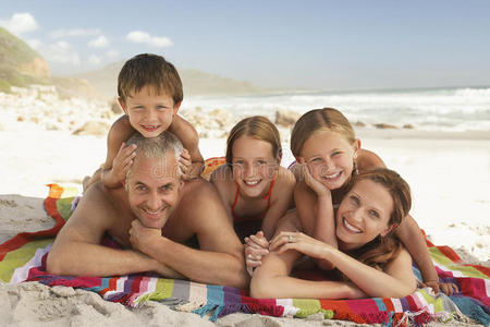幸福的一家人躺在沙滩上图片