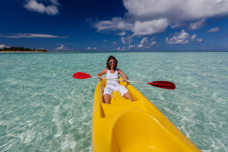 马尔代夫年轻的高加索妇女在海上划独木舟