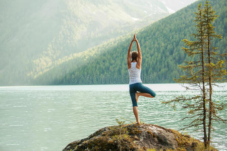 年轻女子在山湖练瑜伽