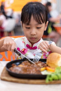 亚洲华人小女孩在餐厅吃西餐图片