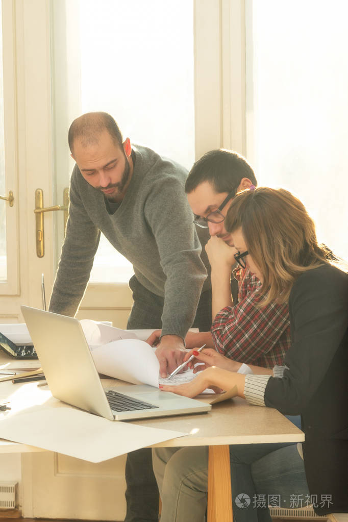 一群普通的年轻人讨论商业计划, 用圈顶, 计划在一间由自然阳光照亮的