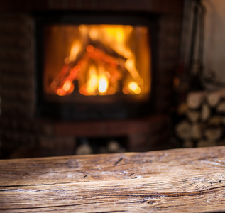 老木桌和壁炉与温暖的炉火的背景