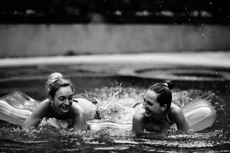 愉快的朋友在酒店的夏季游泳池乐趣