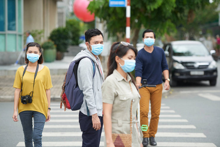 亚洲城市居民因空气污染而在户外面戴口罩散步