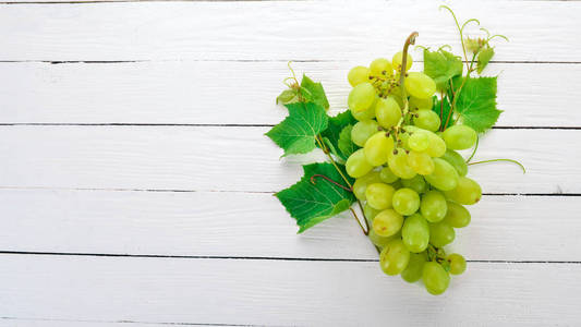 葡萄。白色木质背景的新鲜白葡萄。顶部视图。文本的可用空间