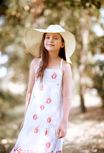 一个女孩走在森林小路上, 穿着长裙, 戴着宽阔的帽子, 明亮的阳光和阴影, 一个美丽的夏日。