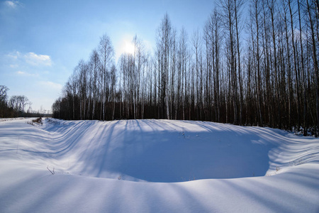 冬季冰雪覆盖下的冰冻农村田野和明亮的阳光