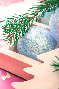 新年圣诞节圣诞假期庆典作文珍珠装饰玩具球木箱冷杉树枝闪光五彩纸屑粉红色纸张背景复制空间模板用于问候明信片文本设计