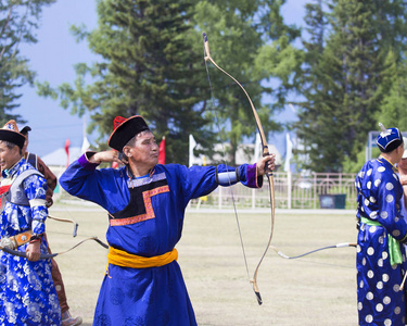 比赛在西伯利亚的体育弓射击。蒙古射箭比赛。这位运动员穿着传统的布里亚特蒙古西服, 在国庆节时用箭射击。