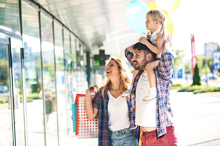 幸福的家庭，走在商场用购物袋和气球