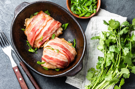 鸡肉裹在熏肉里。顶部视图。石板背景