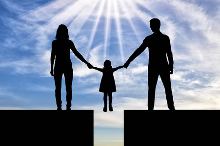 剪影爸爸妈妈握着他的孩子的手, 谁是在悬崖上.