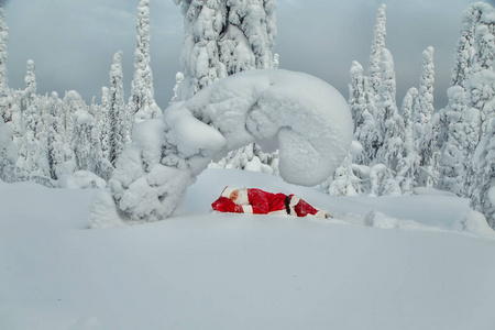 疲倦的圣诞老人在露天睡着了。壮观的雪覆盖的风景
