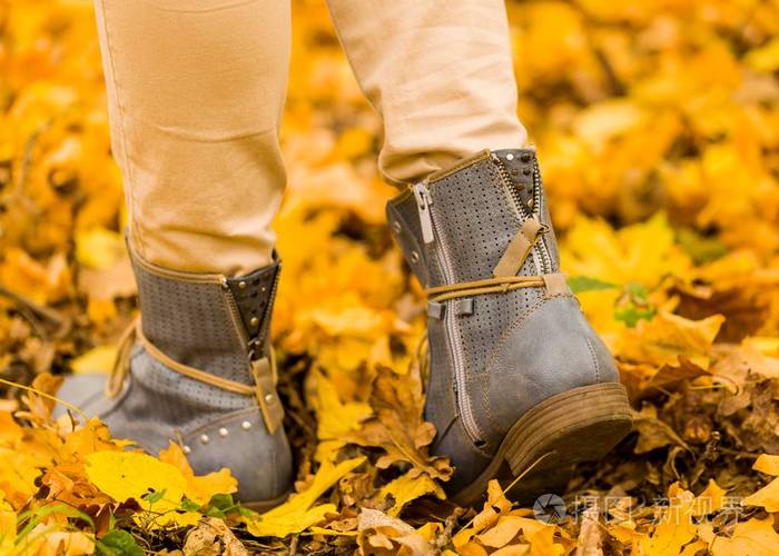 在秋天的地面上行走女性的脚