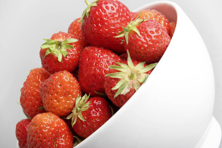一堆明亮的红色草莓在碗里孤立的白色背景, 特写