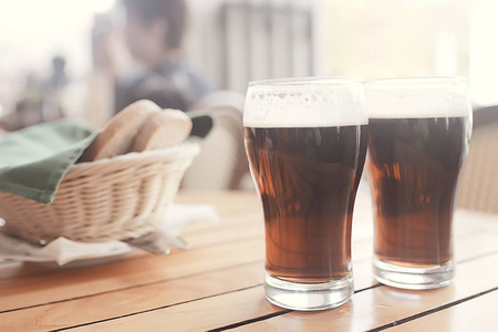 在酒吧内的一杯深色啤酒, 在捷克共和国餐厅供应的桌上有泡沫的啤酒一品脱