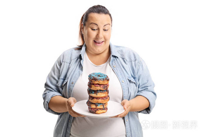 Oveweight 女性看着一堆甜甜圈在一个板块上孤立的白色背景