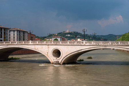古老的历史桥梁维多利亚在维罗纳中心的河对岸。在充气船赛艇运动员游泳。桨是救生衣