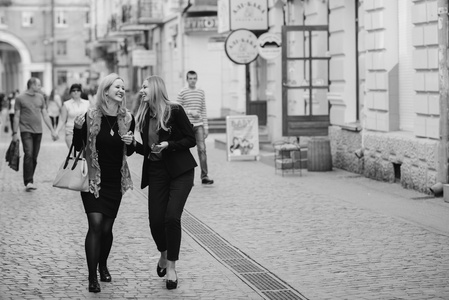 两个漂亮的女孩在城里散步。 女孩们在购物。