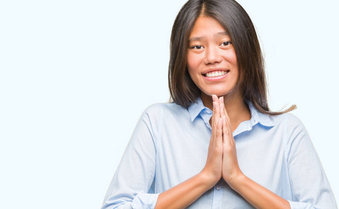 年轻的亚洲商业妇女在孤立的背景祈祷双手一起请求原谅微笑自信