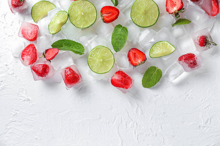 草莓, 薄荷和切片石灰在浅色背景冰块照片