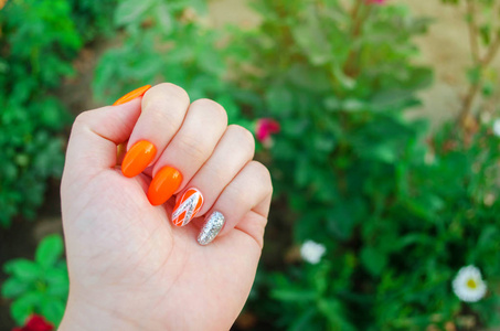 完美的指甲和天然的指甲。迷人的现代指甲艺术设计。橙色秋季设计。长的精心打扮的指甲