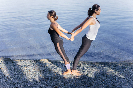 年轻迷人的微笑妇女在湖上练习瑜伽