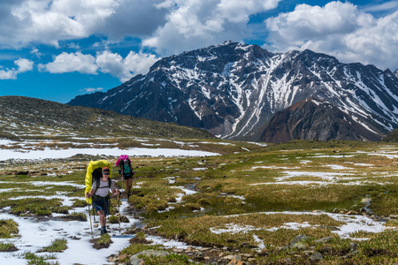 游客走在白雪覆盖的高山草甸，在吞卡范围