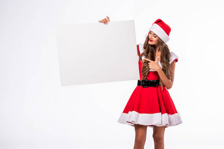 美丽的女孩在圣诞老人服装指向空白板, 孤立的白色