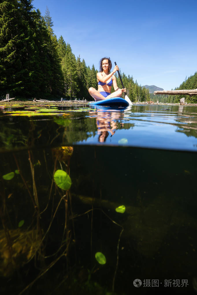 在一个充满活力的阳光明媚的夏日里, 一个女人在一张船上划船.