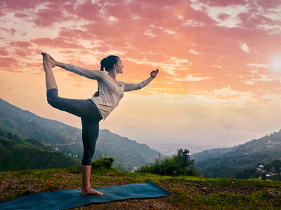 女人做瑜伽体式 natarajasana 户外在瀑布照片