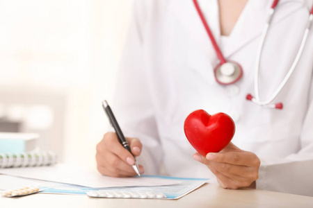 医生与心电图和红色心脏在诊所, 特写