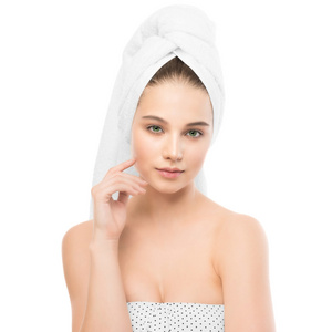 美丽年轻的黑发女人与清洁面部和她头上的毛巾。分离
