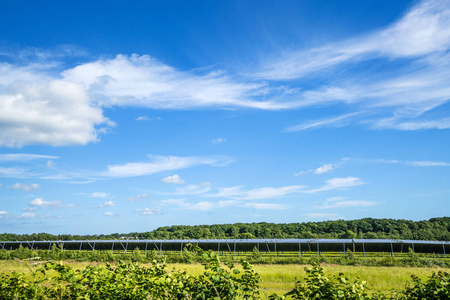夏季蓝天绿地的太阳能电池园生产生态友好能源