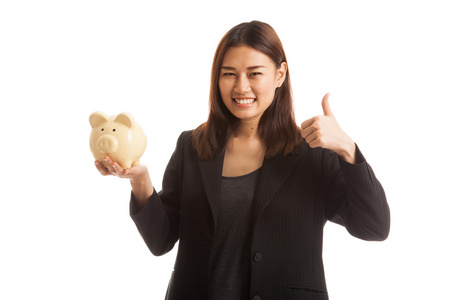 亚洲业务的女人竖起大拇指与猪硬币银行