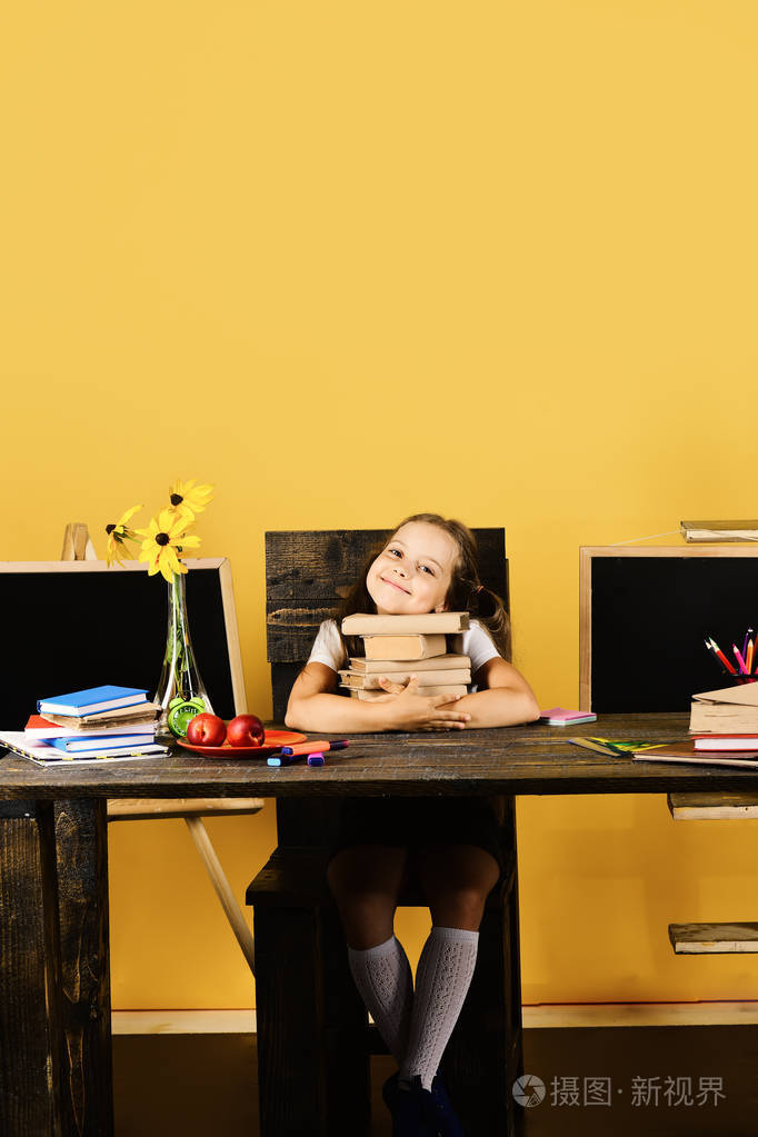 女孩坐在办公桌上, 五颜六色的文具, 鲜花和水果