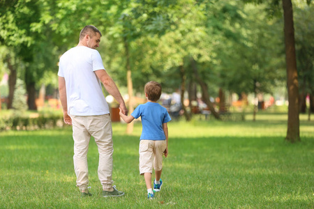 快乐的父亲和儿子在绿色公园