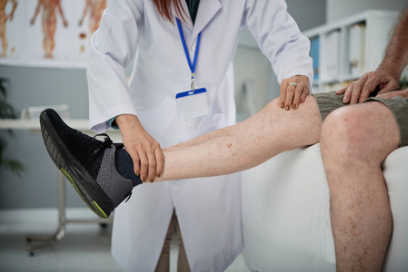 理疗师对老年男性伤害腿的检查