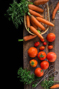 在乡村环境下烹调的新鲜配料 西红柿和胡萝卜。天然有机健康食品的概念。顶部视图