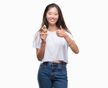 年轻的亚洲妇女持有新鲜的有机在孤立的背景下高兴的大笑做 ok 标志, 拇指与手指, 优秀的标志
