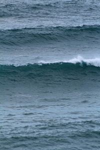 海浪在海岸上破碎, 浪花, 白水和光反射在水面上