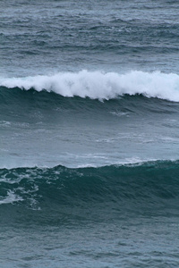 海浪在海岸上破碎, 浪花, 白水和光反射在水面上