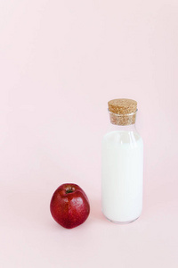 粉红色背景苹果瓶牛奶