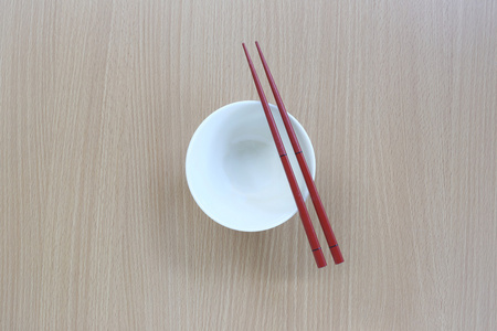 红筷子和在俯视图中木背景上的白色杯