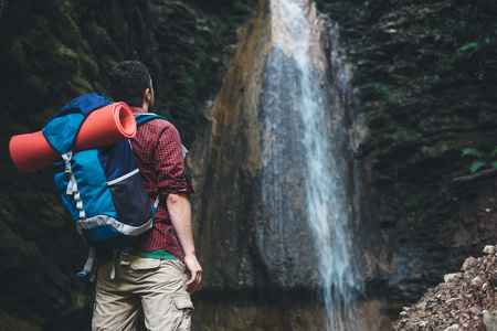 旁边的一个瀑布后山人徒步旅行照片