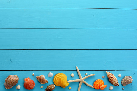 夏季海面背景贝壳，木制的蓝色背景上的明星